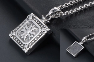 Macro detail of silver square pendant featuring intricate floral relief and vintage finish