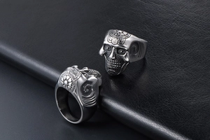 Macro detail showing gothic skull ring carvings with floral patterns and punk textures