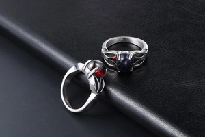 Detail of vintage stainless steel rings with red garnet and blue sandstone gems on leather