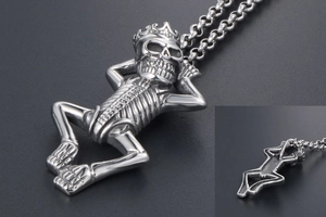 Macro detail of gothic skull with crown pendant made of polished silver steel