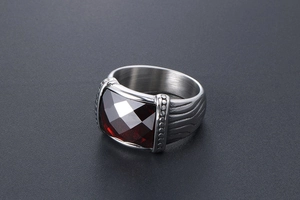Détail macro d'une bague vintage pour homme avec pierre rouge et anneau argent mat