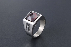 Macro detail of men's titanium steel ring with square red gemstone and textured sides