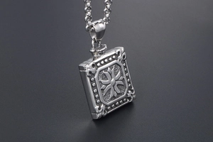 Macro shot of rectangular titanium steel pendant with embossed cross floral texture