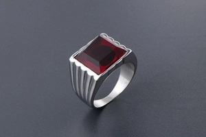 Vista macro di un anello a sigillo da uomo con pietra rossa e fascia in acciaio lavorato
