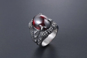 Detailed close-up of dragon claw ring featuring a large red gem and scale textures
