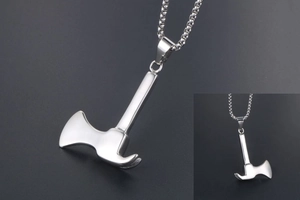 Detailed close-up of polished stainless steel axe and hammer pendant on ball chain necklace
