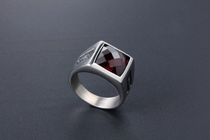 Macro detail of men's titanium ring with square red gemstone and geometric engraving