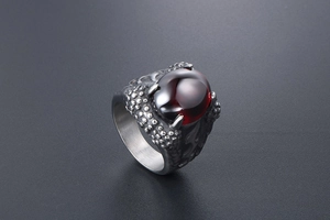 Close-up of dragon claw ring featuring a large oval deep red gemstone in retro style