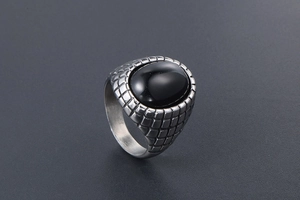 Detail view of oval black agate inlay on vintage silver ring with textured band grid