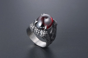 Detail of dragon claw ring featuring a large oval red ruby stone and silver scales