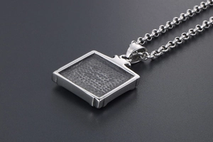 Detailed macro view of silver square pendant with a unique textured honeycomb finish
