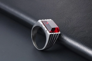 Dettaglio anello vintage da uomo in acciaio con grande pietra preziosa rosso rubino