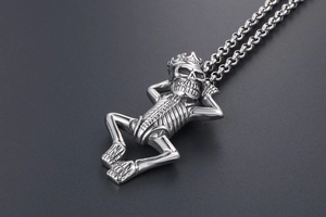 Macro shot of a silver gothic skull pendant wearing a crown in a relaxed lying pose