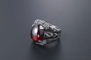 Macro shot of retro dragon claw ring featuring a polished deep red gemstone