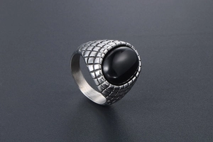 Macro view of vintage silver ring featuring black onyx inlay and textured scale engraving