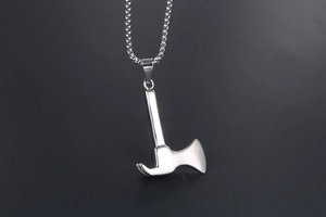 Detailed macro shot of a polished stainless steel axe pendant with a sleek mirror finish