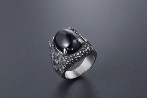 Macro shot of gothic dragon claw ring featuring a black oval gemstone and scales