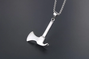 Detailed macro shot of polished stainless steel axe pendant with a pearl round link chain