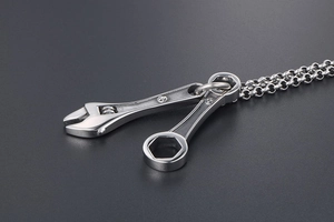 Gros plan d'un collier avec pendentif en forme de clé en acier titane poli industriel