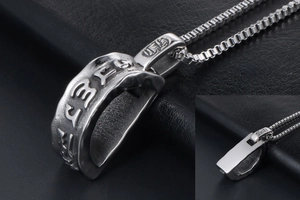 Macro detail of gothic style stainless steel pendant with religious mantra engraving