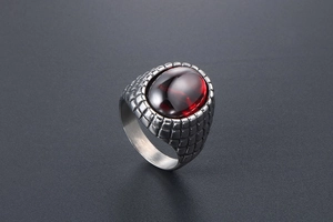 Macro shot of men's vintage silver ring with red agate stone and dragon scale texture