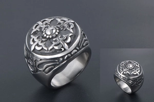 Détail d'une bague vintage en acier titane avec gravure florale et motif croix sculpté