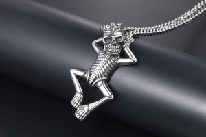 Macro shot of a punk-style skeleton king pendant with a crown on a beaded chain