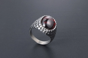 Close-up of vintage men's ring with red gemstone and silver scale texture details