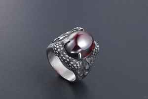Detailed view of gothic dragon claw ring featuring a dark red oval gemstone in titanium steel