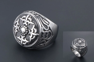 Vue détaillée d'une bague chevalière vintage en acier avec relief floral et oxydation noire