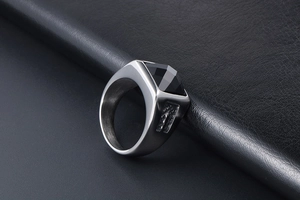 Macro view of men's vintage steel ring featuring a black faceted stone on leather