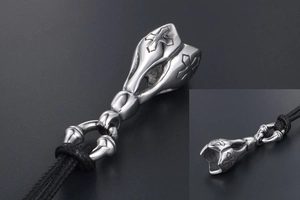 Close-up of vintage punk cross pendant in titanium steel with black woven cord