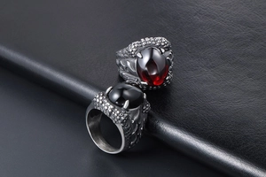 Detailed view of punk dragon claw ring with red and black gemstone inlays and scale texture