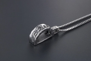 Detailed side view of vintage titanium steel pendant with embossed religious symbols
