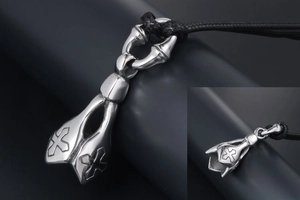 Detail of gothic stainless steel pendant showing the 3D cross relief and woven black cord