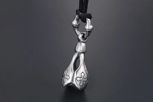 Close-up of vintage stainless steel lotus pendant with embossed cross on black cord