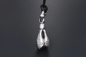 Macro view of vintage titanium steel lotus pendant with cross relief and woven cord