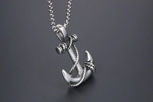 Macro shot of retro stainless steel anchor pendant with intricate rope detail and box chain