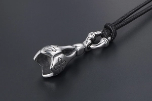Macro shot of silver stainless steel bell pendant with intricate cross engravings
