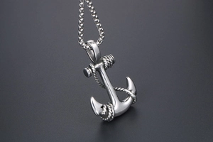 Macro side view of stainless steel anchor pendant with rope detail on box chain