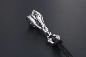 Macro view of a punk lotus cross pendant with silver polished finish and black cord