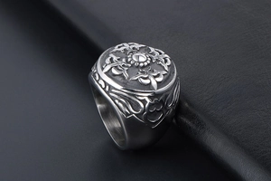 Vue macro d'une bague chevalière vintage avec totem solaire et relief noir sur argent