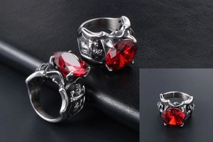Gros plan d'une bague gothique en acier inoxydable avec rubis rouge et gravures