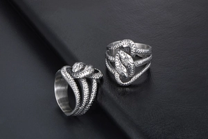 Detail shot of vintage silver snake rings with double heads and scaly punk texture
