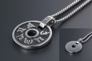 Détail macro du pendentif rond en argent avec mantras bouddhistes et chaîne box