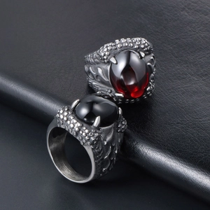 Retro punk dragon claw rings with oval red and black stones on dark leather background