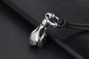 Macro shot of punk style stainless steel lotus bell pendant with engraved cross pattern