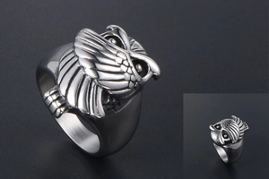Détail macro d'une bague hibou en argent avec gravure de plumes et texture acier rétro