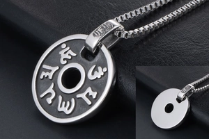 Gros plan du pendentif mantra en acier argenté avec caractères sanskrits et chaîne box