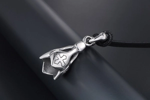 Macro view of vintage titanium steel lotus pendant with embossed cross detail